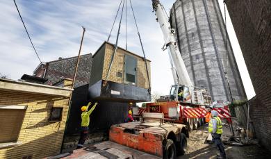 Les équipes de la SWDE installent une cabine haute tension au pied d'un château d'eau